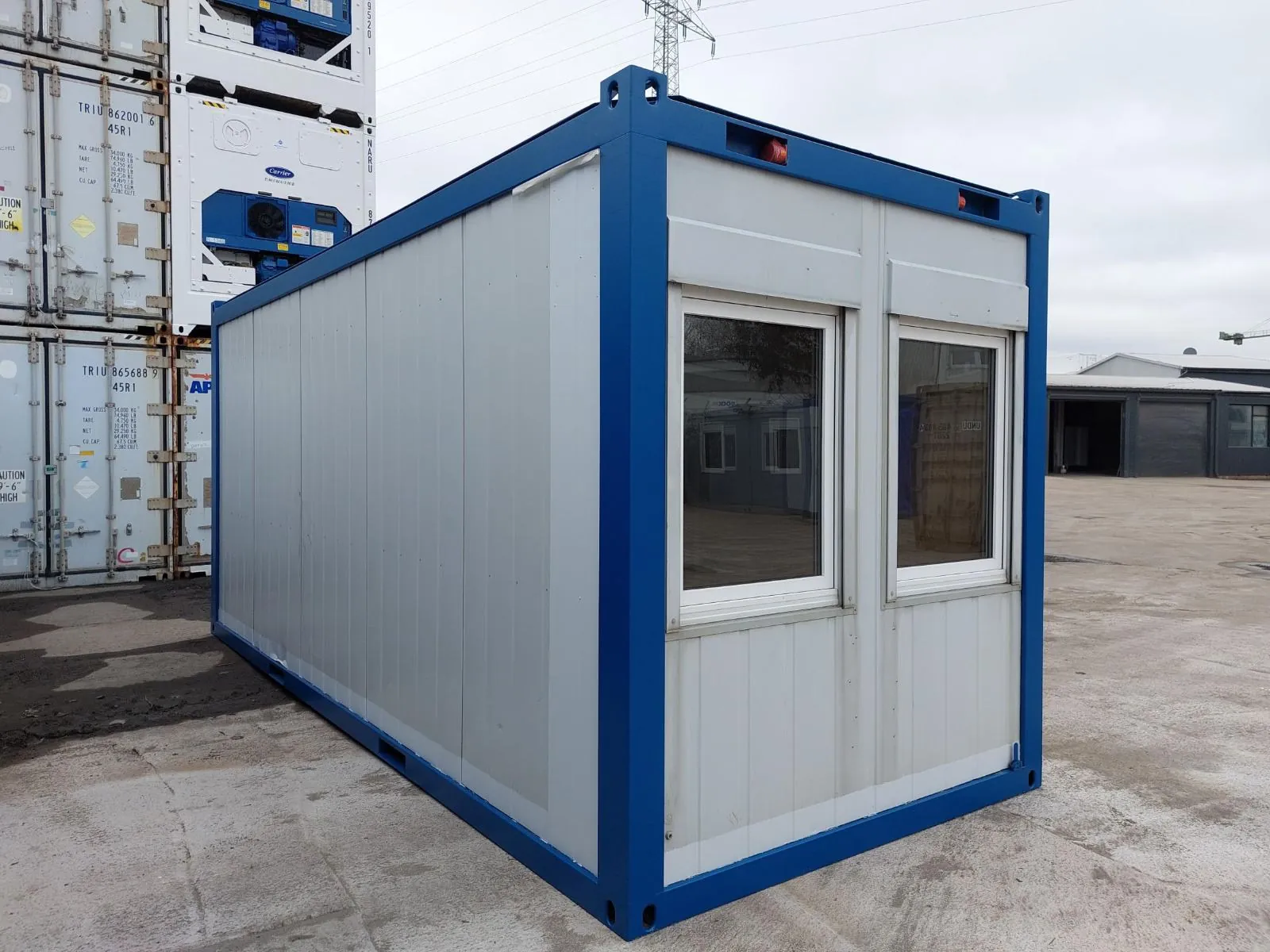 Zum Büro ausgebauter Container mit großer Fensterfront als Gartenbüro