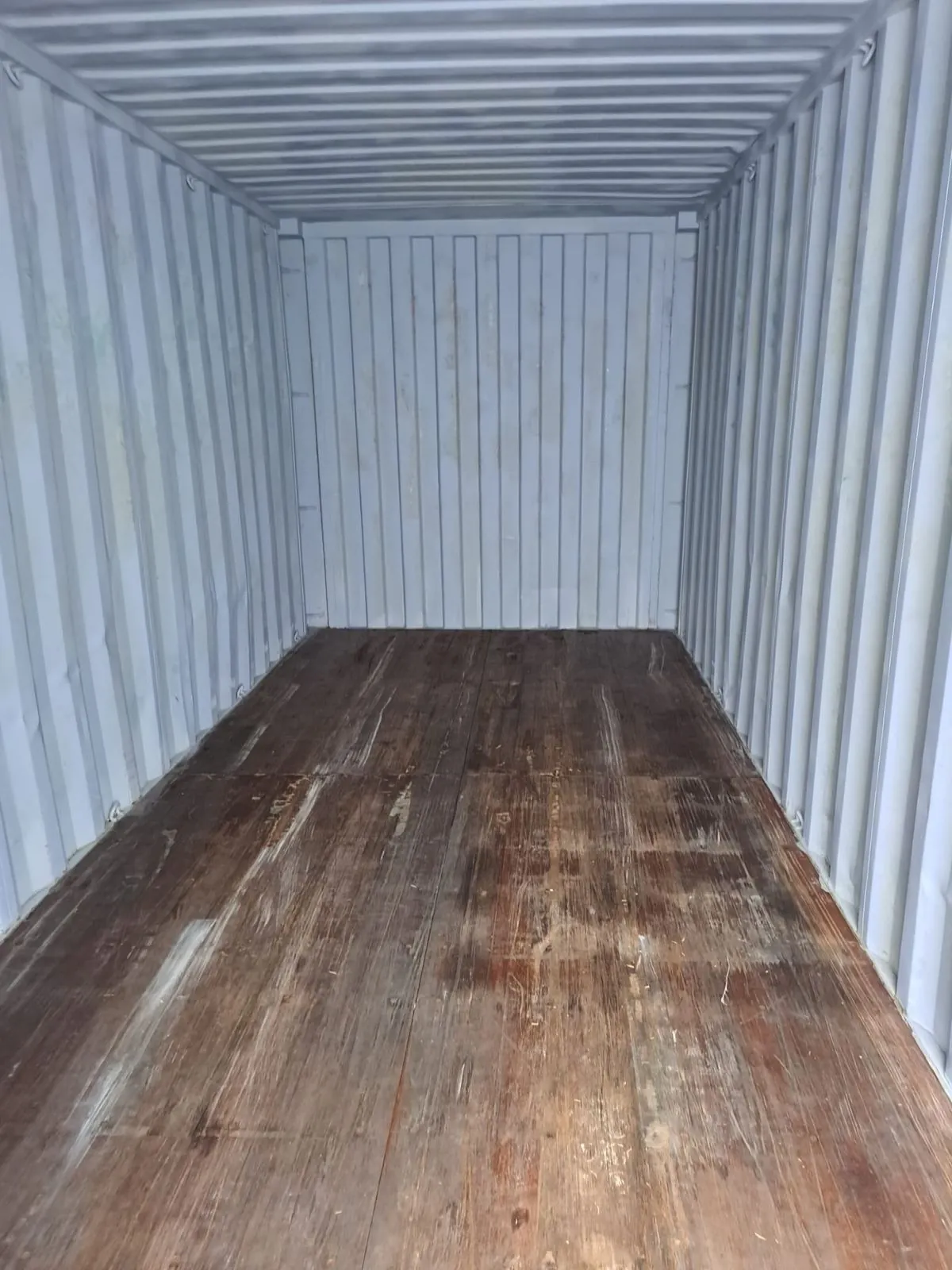 Blick in einen gebrauchten Seecontainer auf den Sperrholzboden