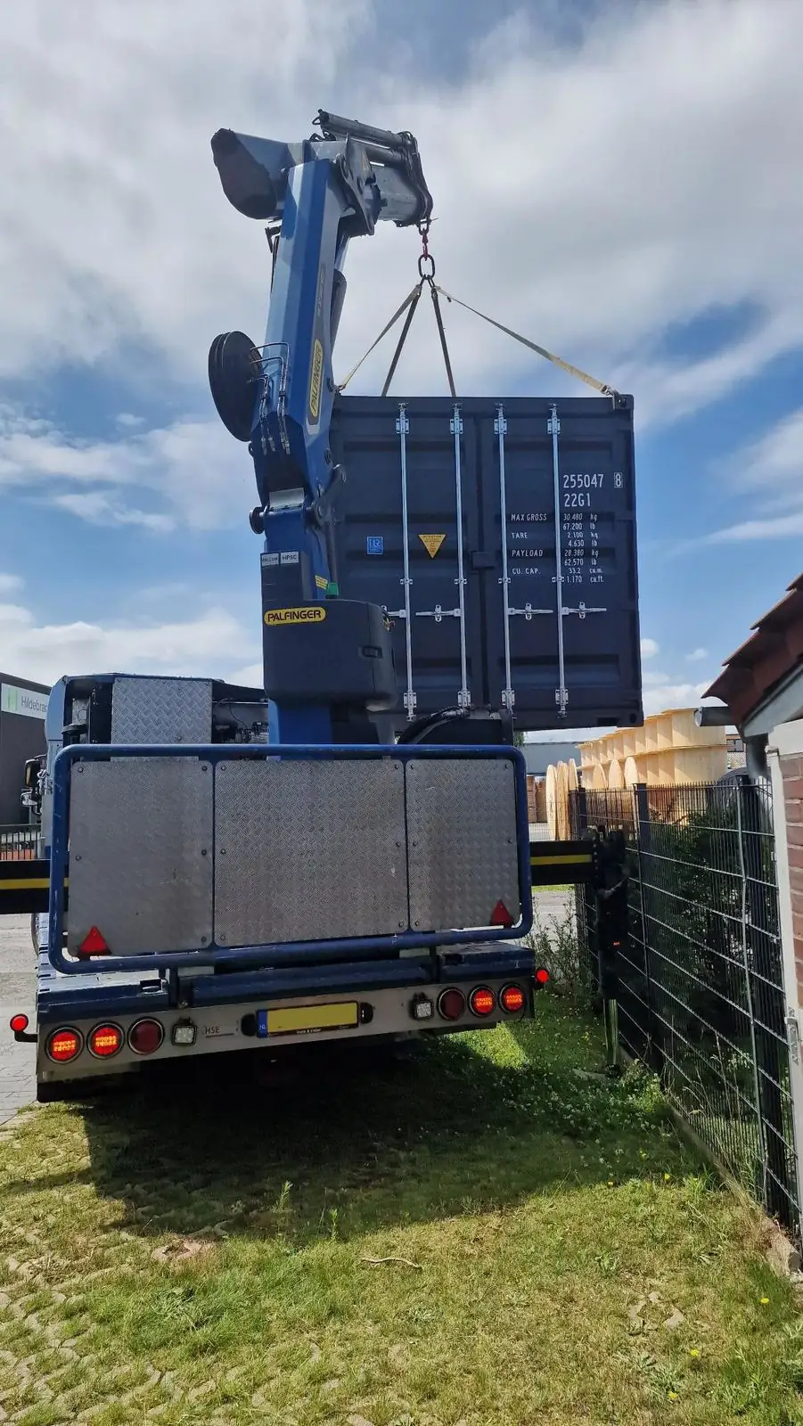 Seecontainer wird mit dem Ladekran des LKW punktgenau abgesetzt