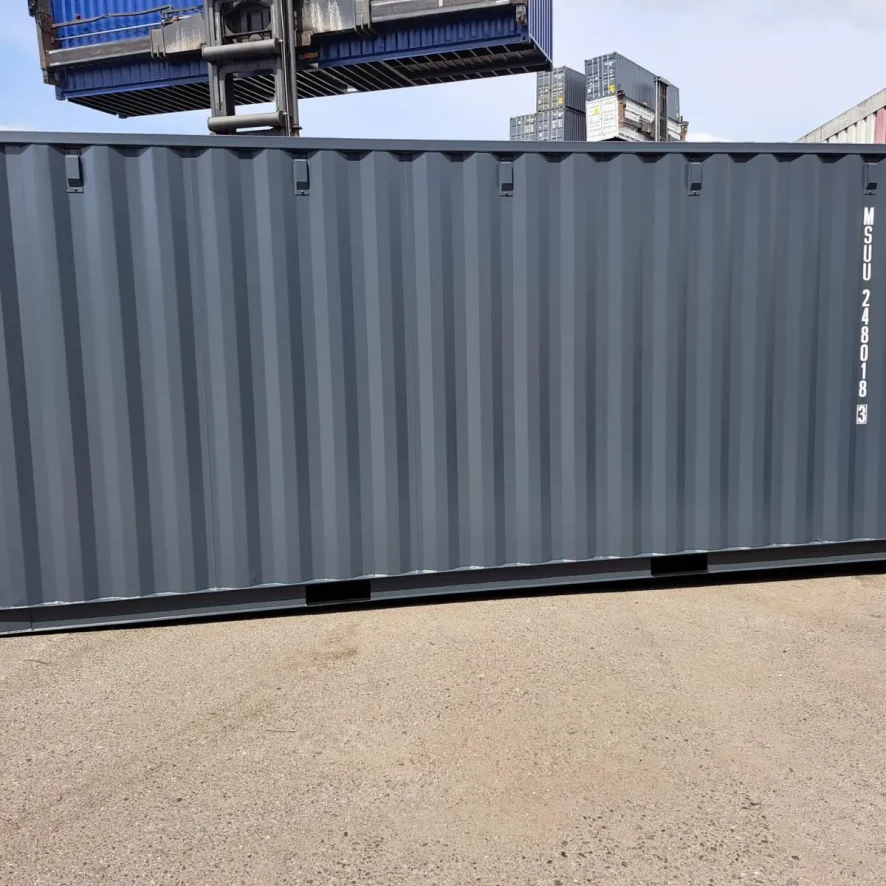 Container kaufen: dunkelgrauer Seecontainer wird mit LKW-Kran auf Baustelle in Hamburg angeliefert