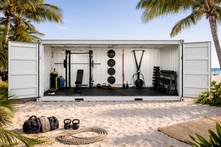 Container kaufen: weißer Fitness-Container als mobiles Strand-Gym mit Hanteln und Trainingsgeräten