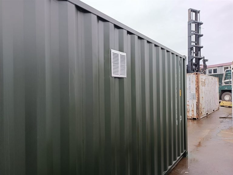 Lüftungsgitter in der Seitenwand des dunkelgrünen Containers