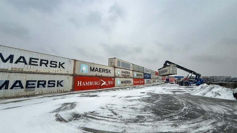 Containerwand aus gebrauchten Containern, Blick entlang der Wand