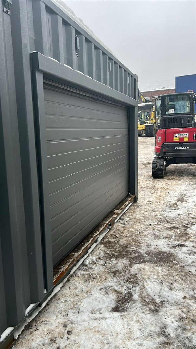 Anthrazit lackierter Container mit eingebautem Rolltor von außen